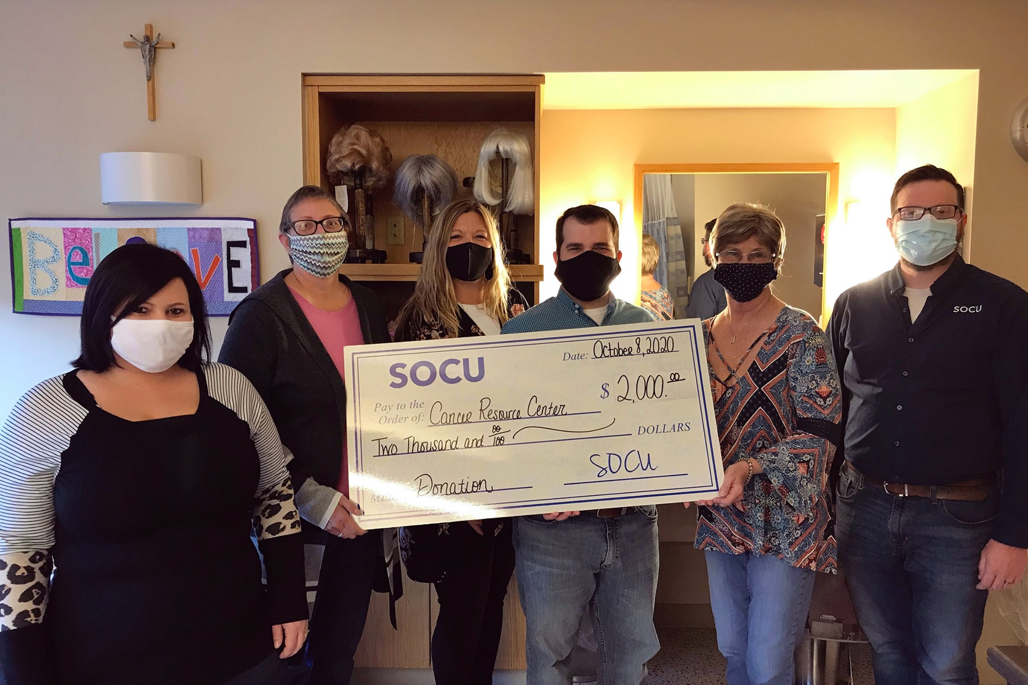 SOCU employees holding a check