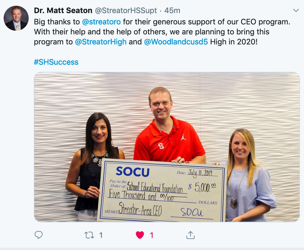 Three people holding a check