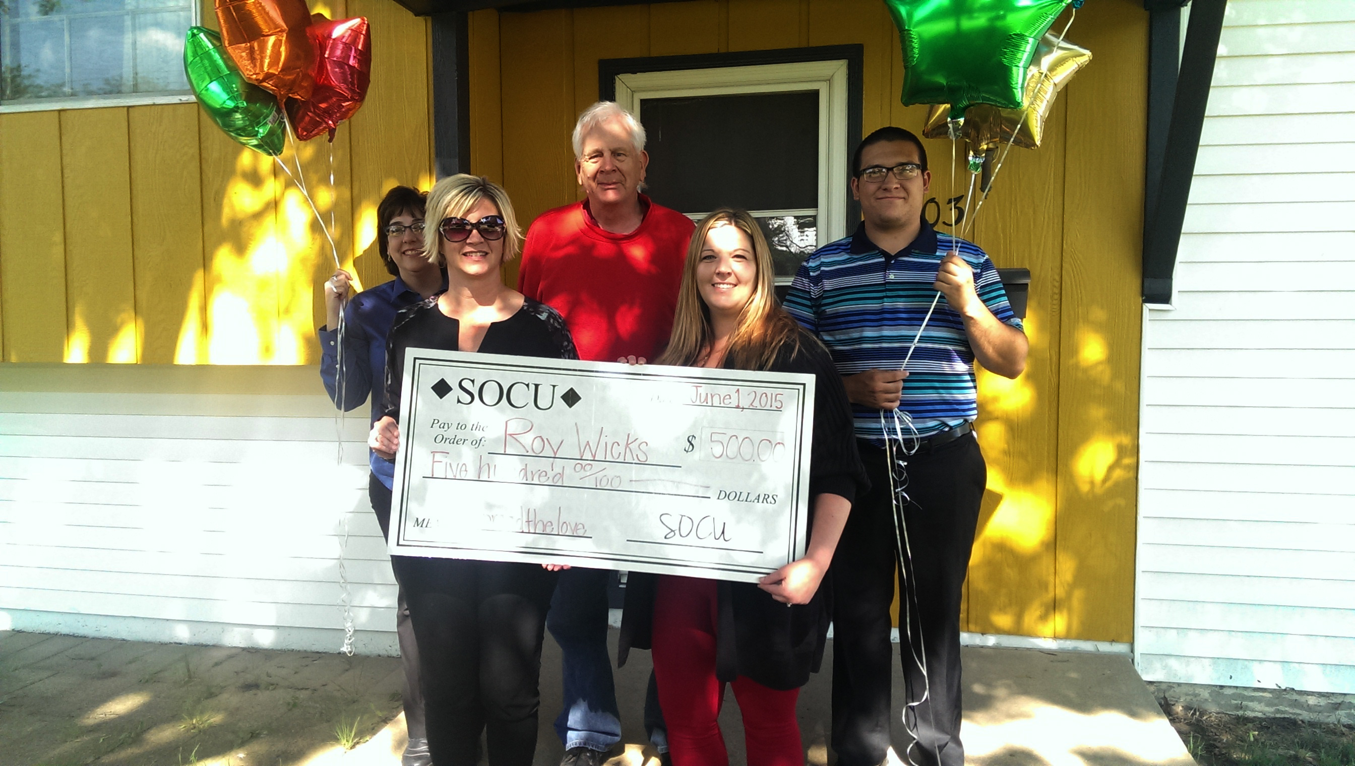 SOCU members presenting giant checks to members.